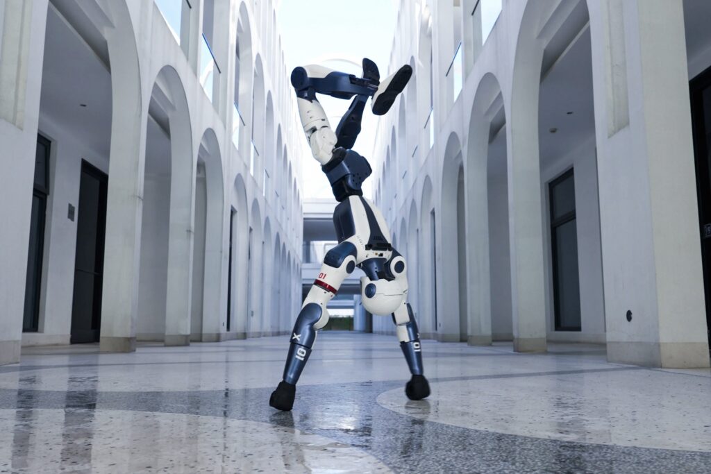 De robotbutler van Unitree doet een handstand in een grote hal.
