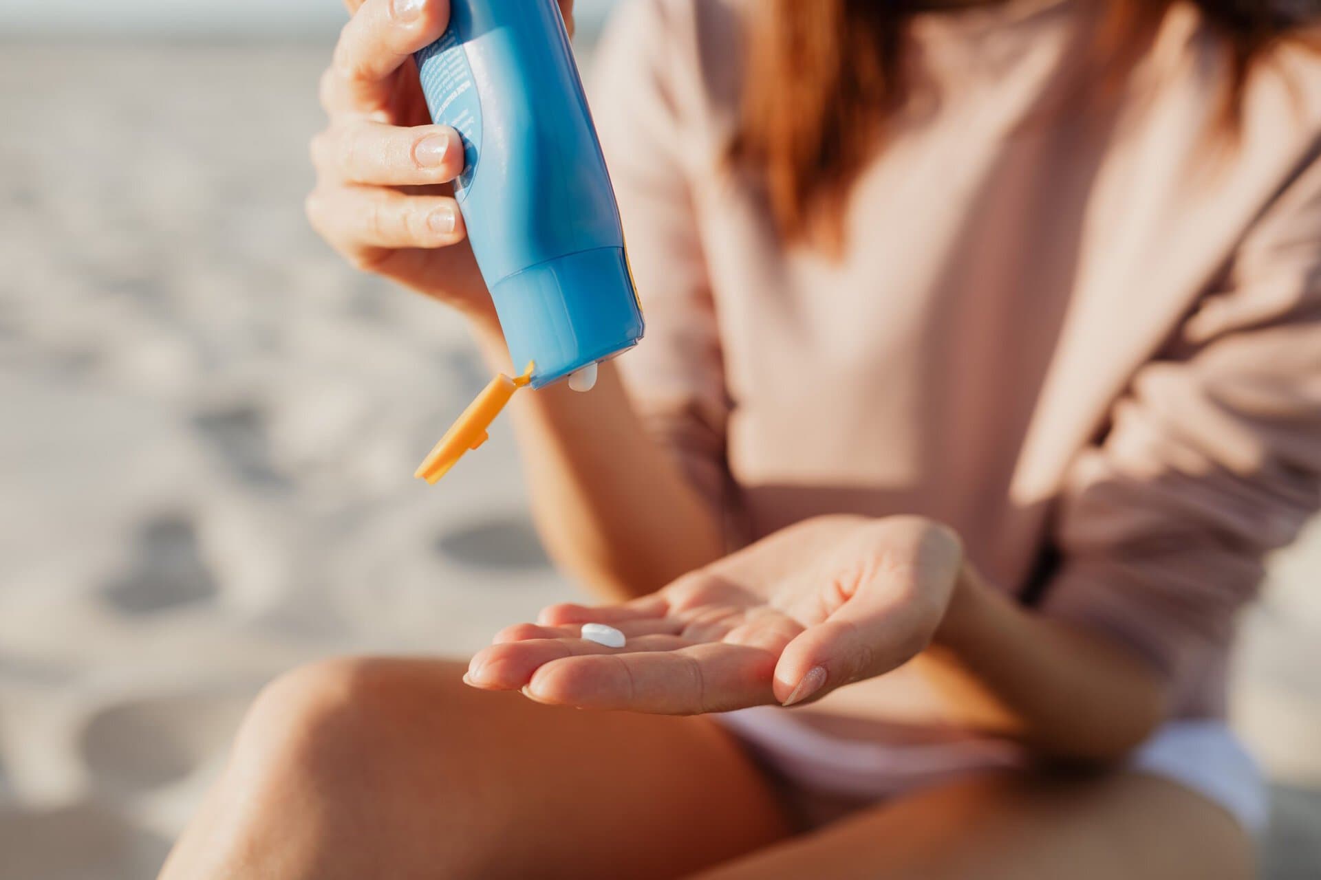 Vrouw die zonnebrandcrème smeert op het strand