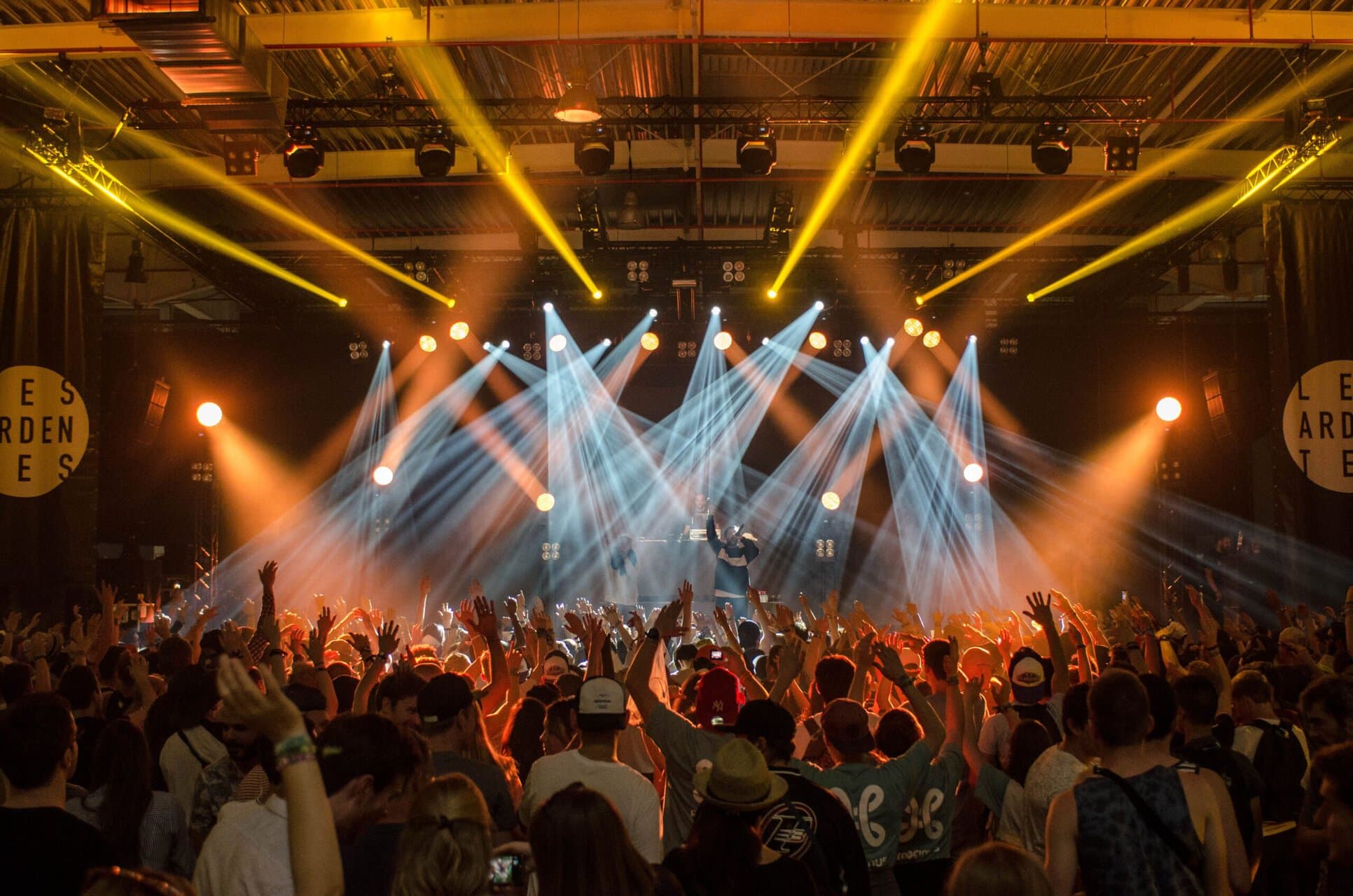 Foto van een concert: een menigte onder flikkerende lichten.